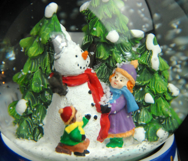 Schneekugel Kinder bauen Schneemann auf Sockel Winterlandschaft Eisläufer blau mit Spieluhr 10 cm Durchmesser - Schneekugelhaus